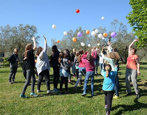 Jugendliche spielen auf der Wiese mit Luftballons