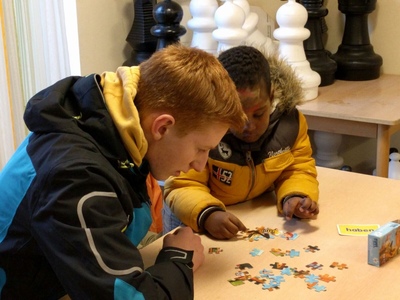 2 Kinder die gemeinsam ein Spiel an einem Tisch spielen