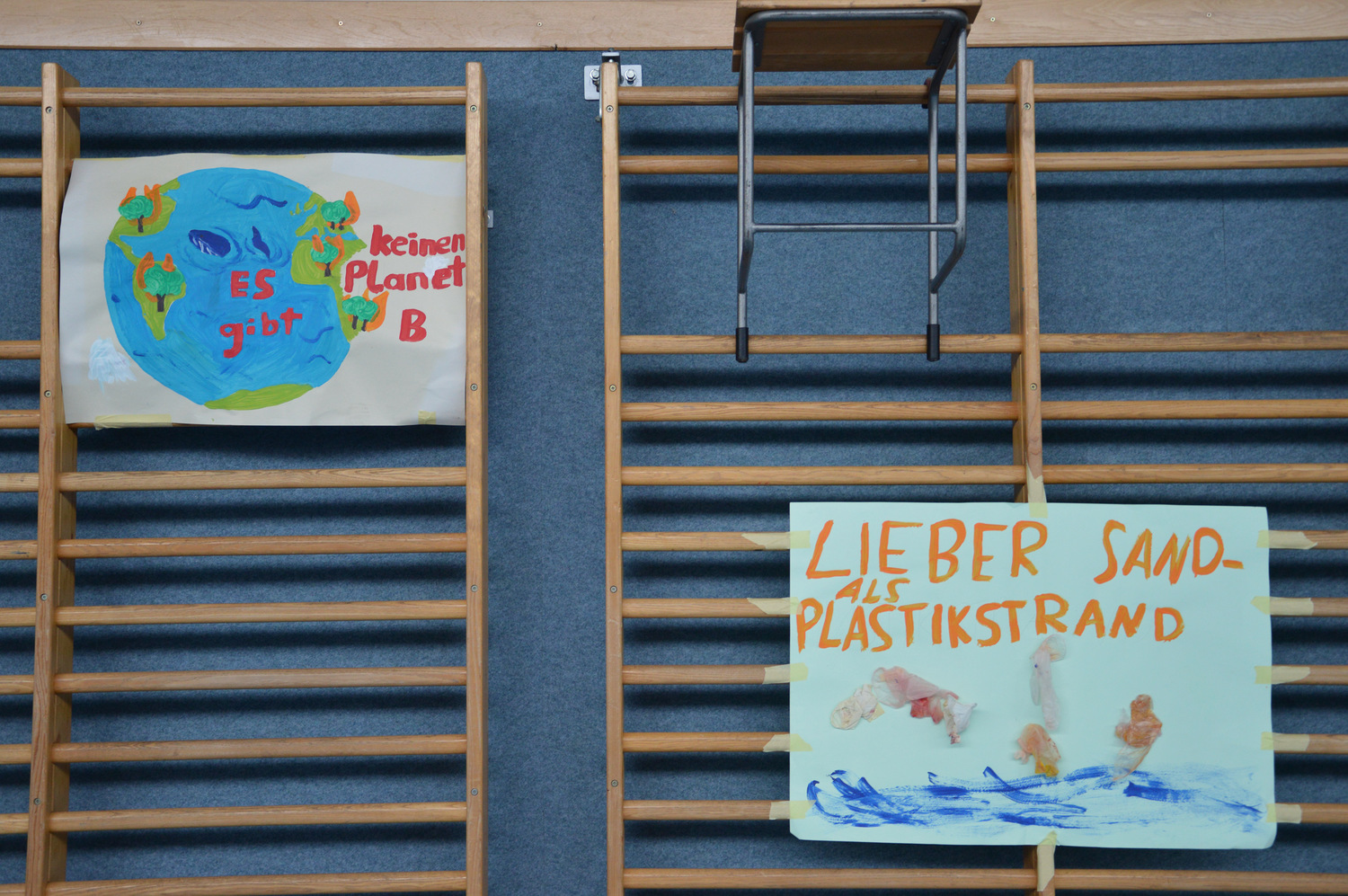 Sproßenwand in Turnhalle mit selbstgemalten Plakaten